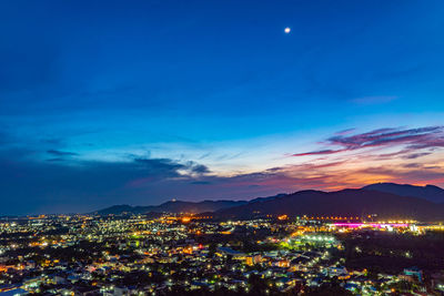 Illuminated cityscape against sky at night