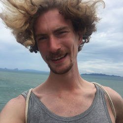 Close-up portrait of smiling mid adult man against sea