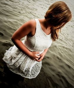 Midsection of woman standing by water