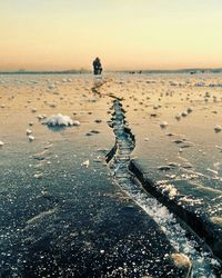 Boy on beach against sky during sunset