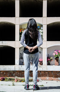 Full length of woman standing against building