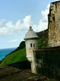 Built structure by sea against sky