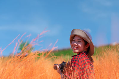 Portrait of woman walking in red meadow in summer