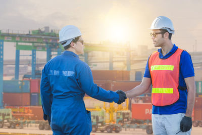 Man working with arms raised standing in city