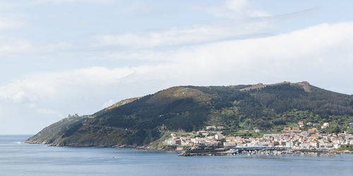 Scenic view of sea by buildings against sky