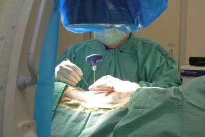 Midsection of surgeon operating patient at hospital