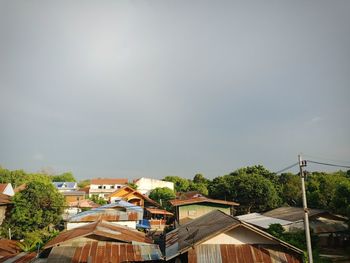 Houses and buildings in town against sky