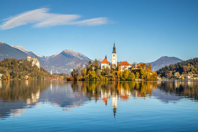 Scenic view of lake by buildings against sky