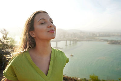 Happy traveler woman enjoying relaxed wind on face at sunset in her vacation