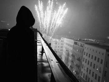 Rear view of silhouette woman standing in park against sky at night