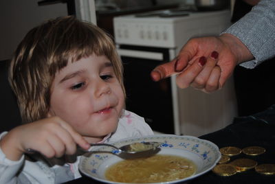 Boy eating noodle soup while sitting at home