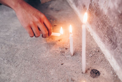 Close-up of hands candles on wall