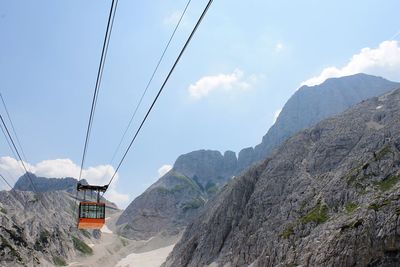 Low angle view of overhead cable car over mountains