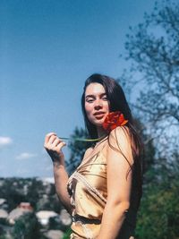 Portrait of woman standing against sky