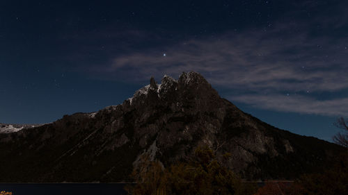 Low angle view of snowcapped mountains against sky at night