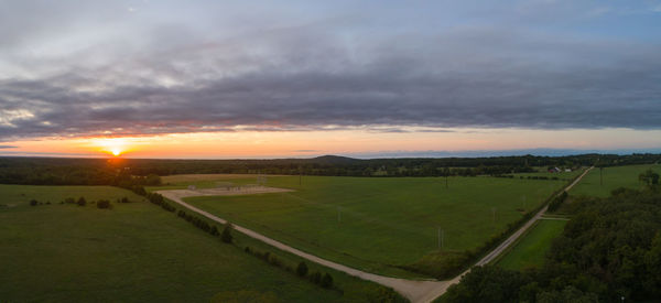 Scenic view of agricultural field against sky during sunset