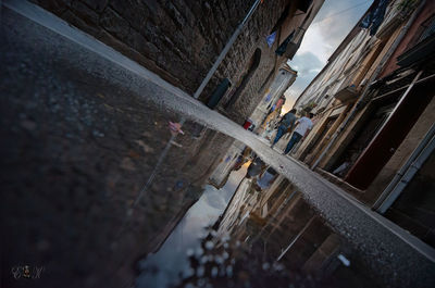 Reflection of buildings in puddle on street