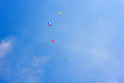 Low angle view of kite flying against blue sky