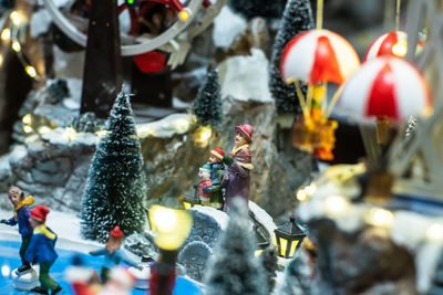 Close-up of figurine with toys in park, christmas property