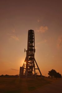 Silhouette ferris wheel against sky during sunset