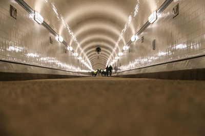 People walking in illuminated tunnel