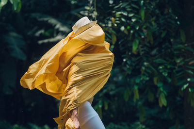 Side view of man covering face with yellow fabric