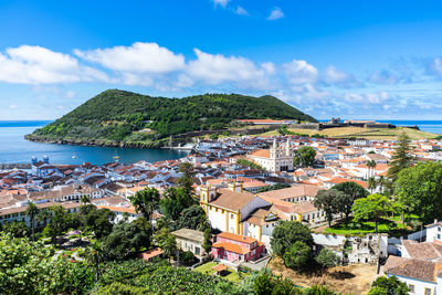 High angle view of townscape by sea against sky