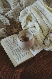 Christmas decorations with lights, hot drink, fruits and a good book