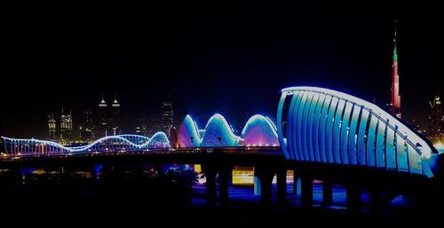 Illuminated bridge over river at night