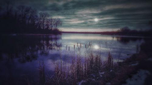 Scenic view of lake against sky at dusk