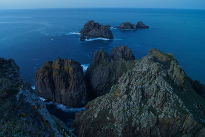 Scenic view of rocks in sea against sky