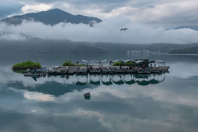 Boats moored in sea against sky