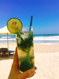 Close-up of drink against clear sky at beach