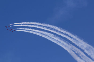 Low angle view of airplanes flying against clear blue sky