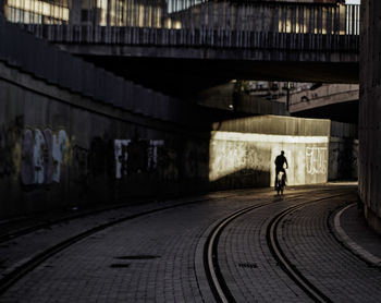 Rear view of person walking on railroad tracks