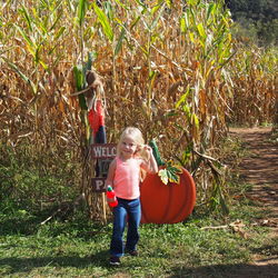 Boy standing on grass against trees