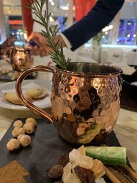 Close-up of hand holding tea cup on table