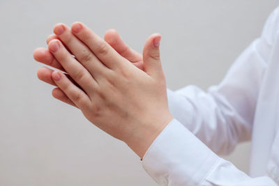 Close-up of hands over white background