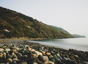 Rocks in sea against clear sky