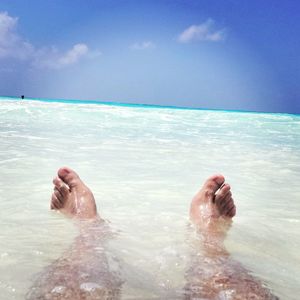 Low section of people relaxing on beach