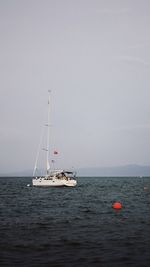 Boat sailing on sea against clear sky