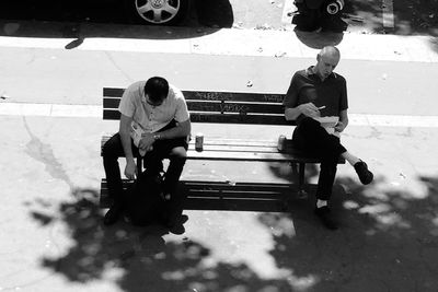 Full length of father with daughter sitting outdoors