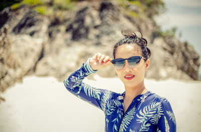 Portrait of young woman wearing sunglasses standing outdoors