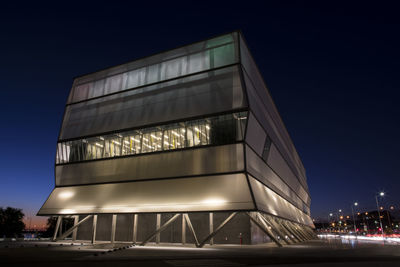 Low angle view of illuminated building against sky at night