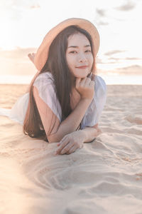 Portrait of young woman relaxing on beach