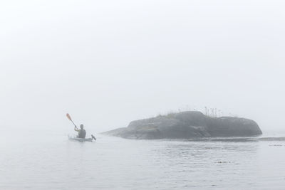 Person paddling in fog, sweden