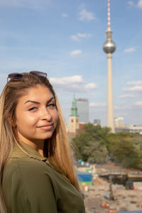 Portrait of smiling young woman against berliner fernsehturm