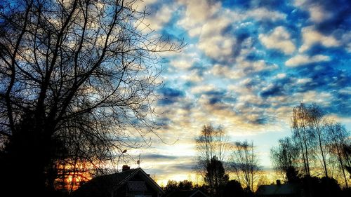 Low angle view of bare tree against cloudy sky