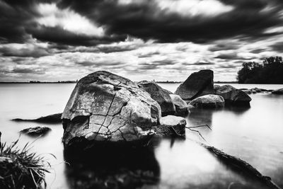 Close-up of rocks in sea against sky