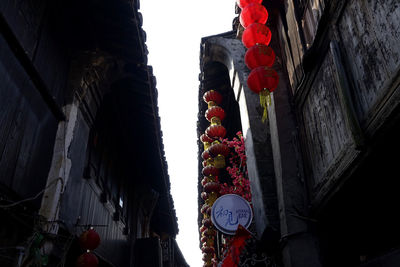 Low angle view of lanterns hanging by building